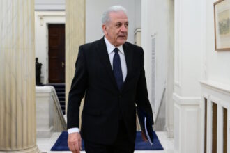 Ο Δημήτρης Αβραμόπουλος σε δημόσια εμφάνιση με φόντο πολιτικό περιβάλλον