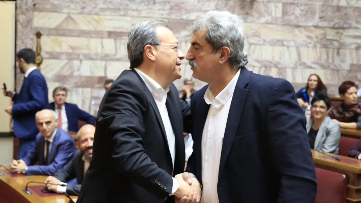 Ο Παύλος Πολάκης και ο Σωκράτης Φάμελλος σε πολιτικό κάδρο με φόντο το λογότυπο του ΣΥΡΙΖΑ