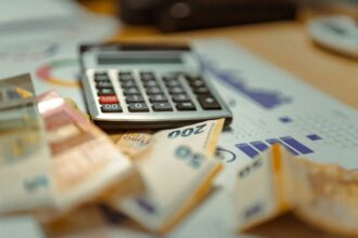Χαρτιά και λογαριασμοί που συμβολίζουν ρύθμιση παλαιών οφειλών έως 72 δόσεις