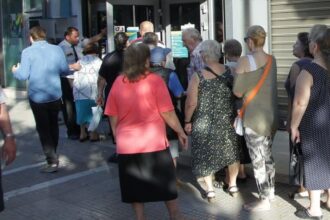 Συνταξιούχος κρατά χαρτιά με πληροφορίες για σύνταξη χηρείας και συντάξεις