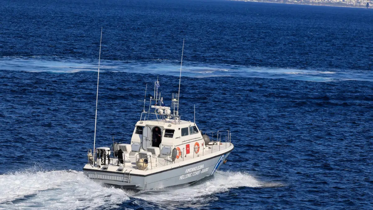 Πλοίο στο λιμάνι της Ελαφονήσου με ανοιχτό καταπέλτη και άνθρωπο στη θάλασσα να κολυμπά προς αυτό