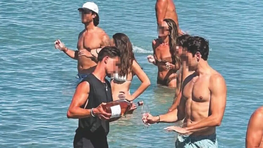 Σερβιτόρος μπαίνει στη θάλασσα για να σερβίρει πελάτη σε beach bar στην Πάρο