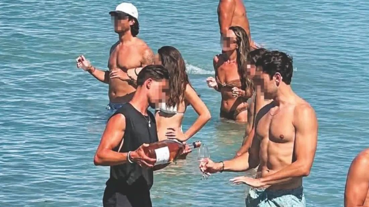 Σερβιτόρος μπαίνει στη θάλασσα για να σερβίρει πελάτη σε beach bar στην Πάρο