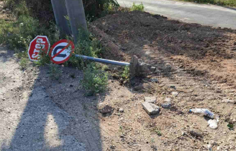 Πεσμένες πινακίδες οδικής σήμανσης και στύλος στήριξης στην άκρη του δρόμου στον Καραβόμυλο