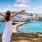 Πινακίδα για το πρόγραμμα Τουρισμός για Όλους με φόντο καλοκαιρινό τουριστικό προορισμό